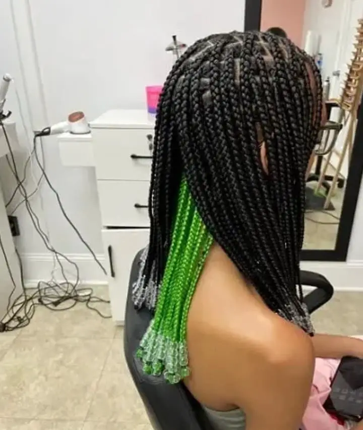 hidden behind the black braids of green